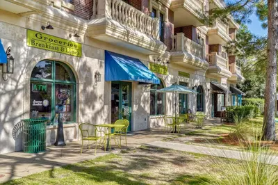 a building with chairs and tables outside of it at Newly Renovated Professionally Decorated Gulf Views! Pool & Beach Access in Rosemary Beach