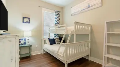 a bedroom with a bunk bed and a desk at Emerald Gem by AvantStay Pool Access 3mins to Beach in Panama City Beach