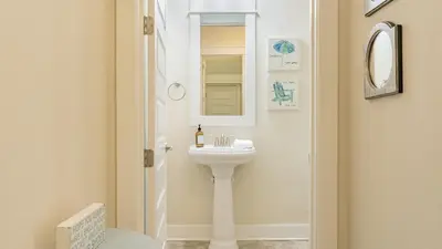 a white bathroom with a sink and a mirror at Emerald Gem by AvantStay Pool Access 3mins to Beach in Panama City Beach