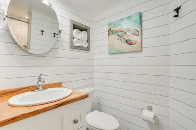 a white bathroom with a sink and a mirror at Beachfront Panama City Condo with Balcony and Views! in Panama City