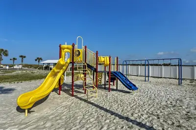 a playground with a slide on the beach at Beachfront Panama City Condo with Balcony and Views! in Panama City