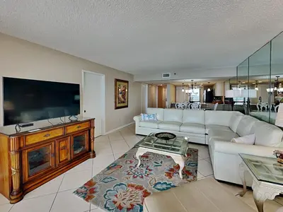 a living room with a white couch and a flat screen tv at Edgewater Tower Iii 1111 in Panama City Beach