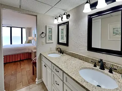 a bathroom with two sinks and a bedroom with a bed at Edgewater Tower Iii 1111 in Panama City Beach