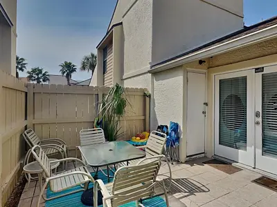 a patio with chairs and a table and a fence at Horizon South #31A in Panama City Beach