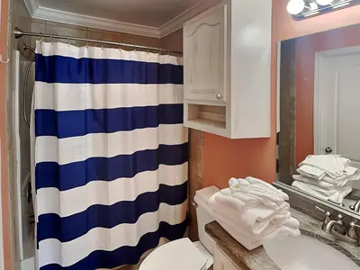 a bathroom with a blue and white striped shower curtain at Horizon South #31A in Panama City Beach