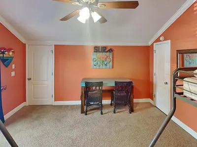 a dining room with orange walls and a ceiling fan at Horizon South #31A in Panama City Beach