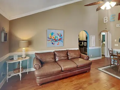 a living room with a brown couch and a table at Horizon South #31A in Panama City Beach