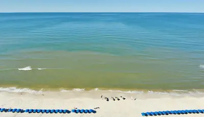 a group of people standing on the beach at Beachfront Oasis at Splash Resort and Condos in Panama City Beach