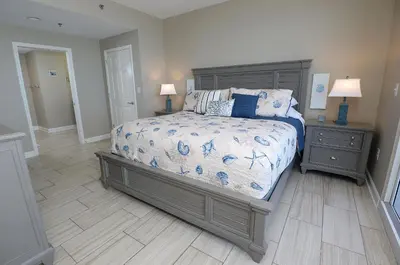 a bedroom with a bed and a wooden floor at Beachfront Oasis at Splash Resort and Condos in Panama City Beach