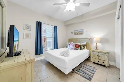 a bedroom with a bed and a flat screen tv at Gulf Crest 205 - Stunning Gulf Views - Huge Balcony in Panama City Beach