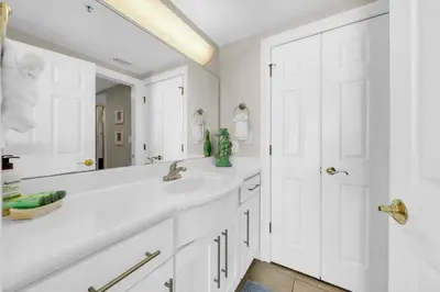 a white bathroom with a sink and a mirror at Gulf Crest 205 - Stunning Gulf Views - Huge Balcony in Panama City Beach