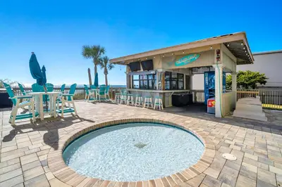 a pool in a patio with chairs and a restaurant at Gulf Crest 205 - Stunning Gulf Views - Huge Balcony in Panama City Beach
