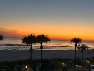 a sunset over the beach with palm trees at Gulf Crest 205 - Stunning Gulf Views - Huge Balcony in Panama City Beach