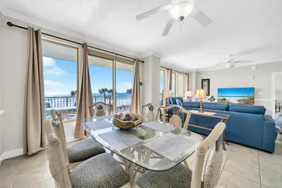 a living room with a glass table and chairs at Gulf Crest 205 - Stunning Gulf Views - Huge Balcony in Panama City Beach