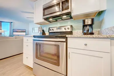 a kitchen with a stove and a microwave at Sunbird Resort! Ground-Floor Renovated Beach Condo! Free Beach Chairs! by Dolce Vita Getaways PCB in Panama City Beach