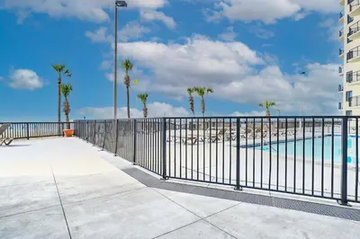 a balcony with a fence and a swimming pool at Sunbird Resort! Ground-Floor Renovated Beach Condo! Free Beach Chairs! by Dolce Vita Getaways PCB in Panama City Beach