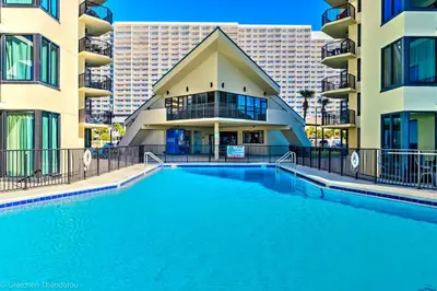 a large swimming pool in front of a building at Sunbird Resort! Ground-Floor Renovated Beach Condo! Free Beach Chairs! by Dolce Vita Getaways PCB in Panama City Beach