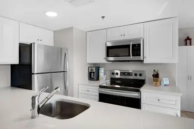 a kitchen with white cabinets and a stainless steel appliances at Sunbird 601W in Panama City Beach