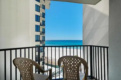 two chairs on a balcony with a view of the beach at Sunbird 601W in Panama City Beach