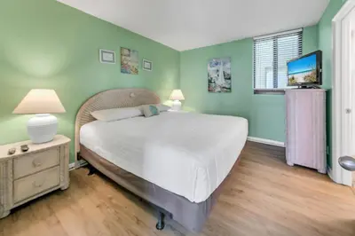 a bedroom with a bed and a television in it at Sunbird 906W in Panama City Beach