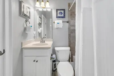 a white bathroom with a toilet and a sink at Lily Pad in Panama City Beach