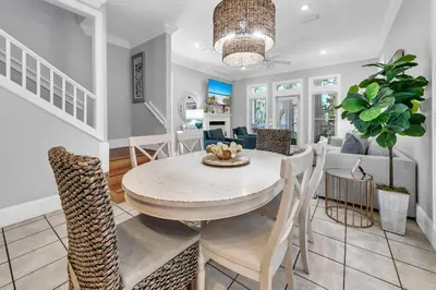a dining room and living room with a table and chairs at Lily Pad in Panama City Beach