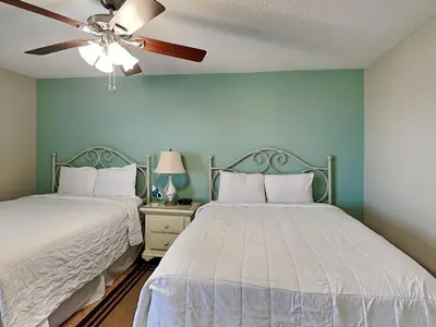 two beds in a bedroom with a ceiling fan at Edgewater Tower Ii 403 in Panama City Beach