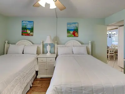 a bedroom with two beds and a table at Edgewater Tower Ii 403 in Panama City Beach