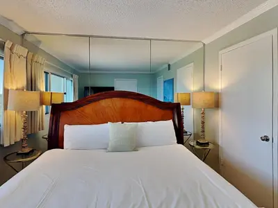 a bedroom with a bed with a mirror above it at Pinnacle Port a-702 in Panama City Beach
