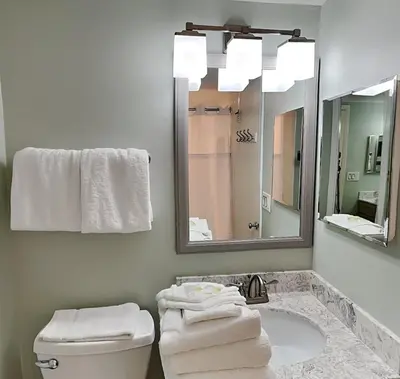 a bathroom with a toilet and a sink with a mirror at Pinnacle Port a-702 in Panama City Beach