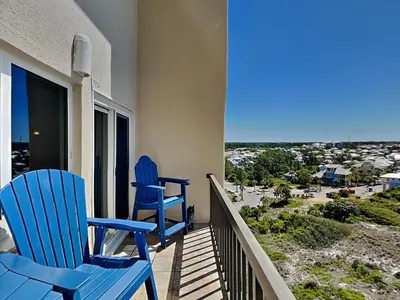 two blue chairs sitting on a balcony with a view at Pinnacle Port a-702 in Panama City Beach