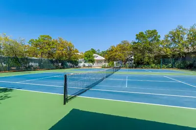 a tennis court with a net on top of it at Cassine Gardens by Panhandle Getaways in Santa Rosa Beach