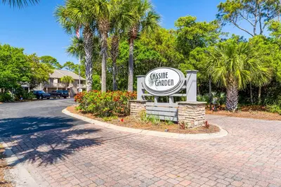 a sign for a hotel on a street with palm trees at Cassine Gardens by Panhandle Getaways in Santa Rosa Beach