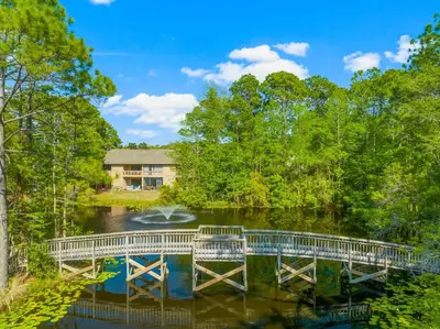 a bridge over a river with a house in the background at Cassine Gardens by Panhandle Getaways in Santa Rosa Beach