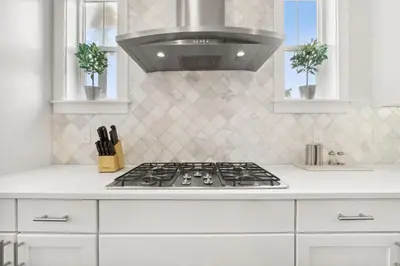a white kitchen with a stove and a hood at Coastal Cottage at 30A in Inlet Beach
