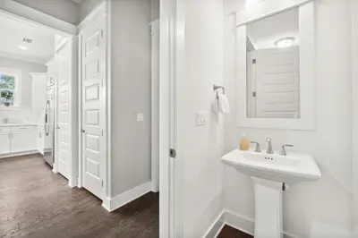a white bathroom with a sink and a mirror at Coastal Cottage at 30A in Inlet Beach