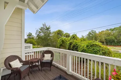a porch with two chairs and a table at Coastal Cottage at 30A in Inlet Beach