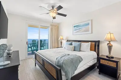 a bedroom with a bed and a view of the ocean at Sterling Breeze 1507 in Panama City Beach
