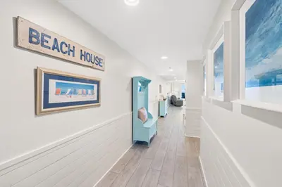 a hallway with a beach house sign on a wall at Sterling Breeze 1507 in Panama City Beach