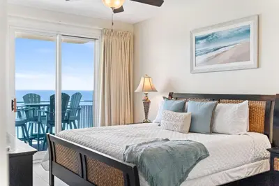 a bedroom with a bed with a view of the ocean at Sterling Breeze 1507 in Panama City Beach