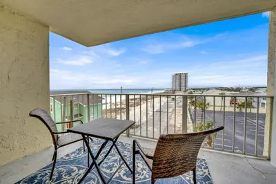 a balcony with a table and chairs and a view of the ocean at Regency Towers 404 in Panama City Beach