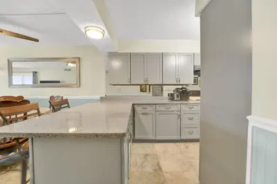 a large kitchen with white cabinets and a table at Regency Towers 404 in Panama City Beach