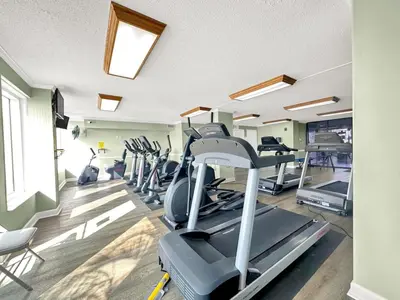 a gym with several treadmills and a treadmill at Regency Towers 404 in Panama City Beach