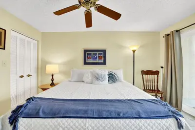 a bedroom with a bed with a ceiling fan at Regency Towers 404 in Panama City Beach