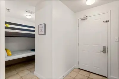 a room with a closet with a bed and a door at Gulf-Front Shores of Panama Condo w/ Balcony & Resort Amenities in Panama City Beach
