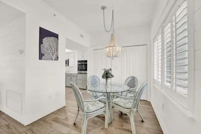 a dining room with a glass table and chairs at Coral Reef 1001 in Panama City Beach