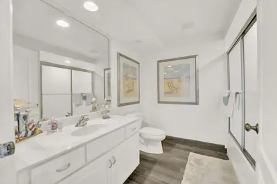 a white bathroom with a toilet and a sink at Coral Reef 1001 in Panama City Beach