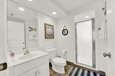 a white bathroom with a toilet and a sink at Coral Reef 1001 in Panama City Beach