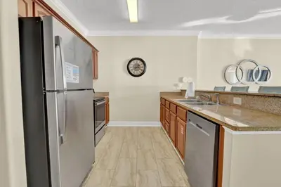 a kitchen with a stainless steel refrigerator and a sink at Family-Friendly 4BR Beachfront Retreat w/ Indoor & Outdoor Pools in Panama City Beach