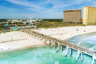 an aerial view of a beach and a pier at Family-Friendly 4BR Beachfront Retreat w/ Indoor & Outdoor Pools in Panama City Beach